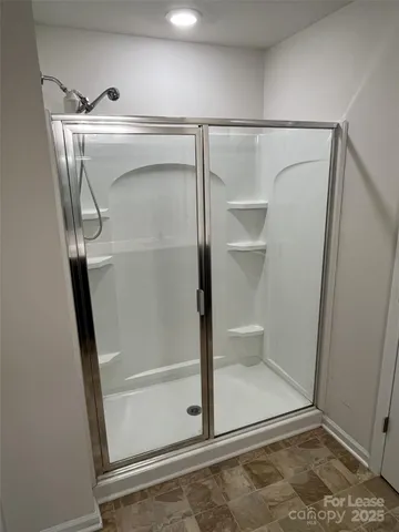 a bathroom with a glass shower door