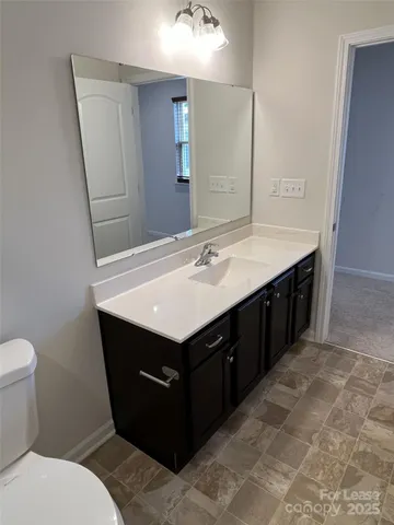 a bathroom with a sink vanity and toilet