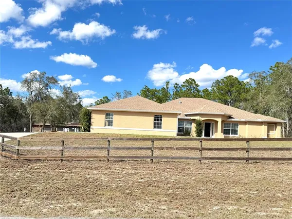 a white house that has a tree in front of it