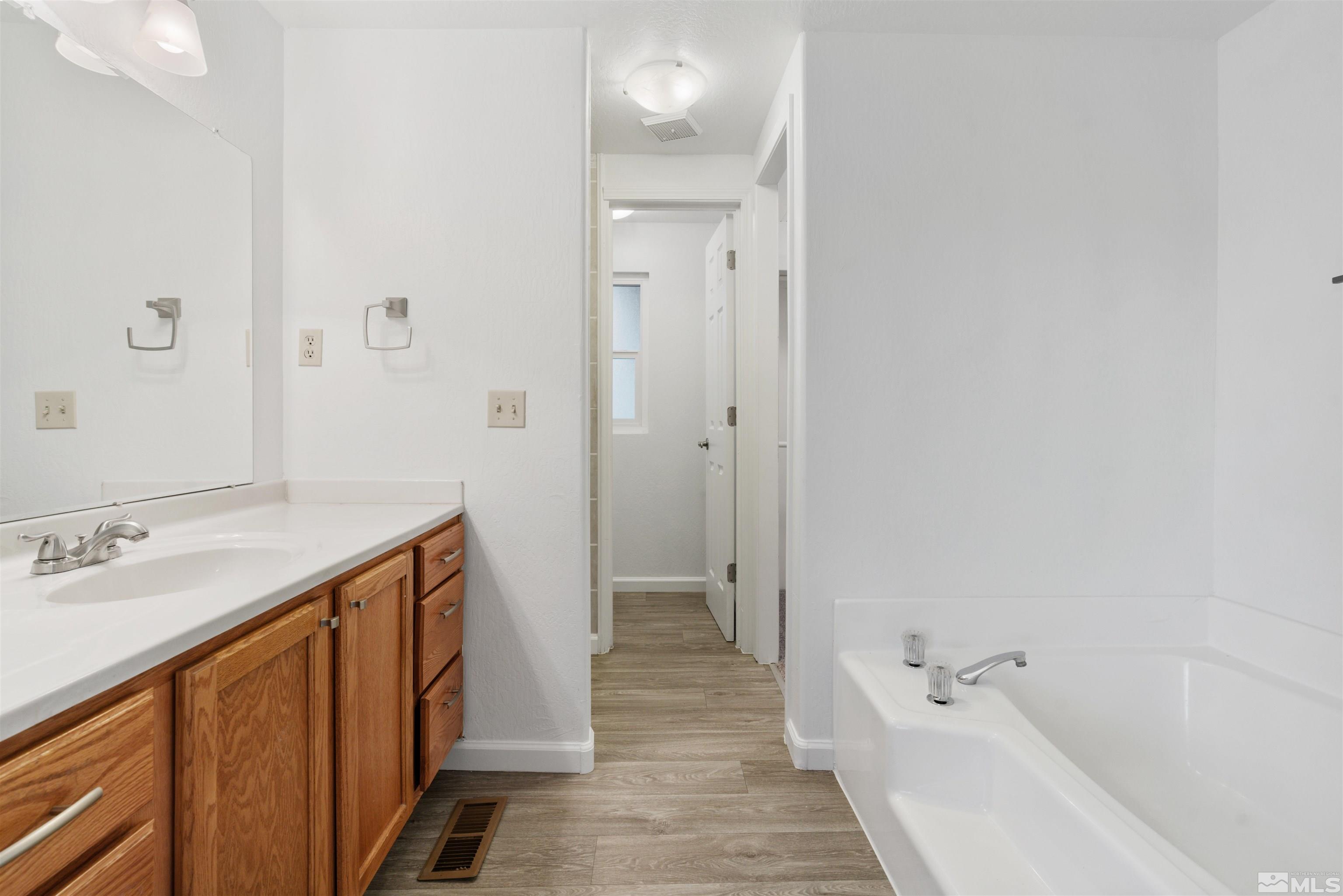 210 Zircon Drive Reno, NV 89521 - Photo 10 of 35 a bathroom with a sink a mirror and a bathtub