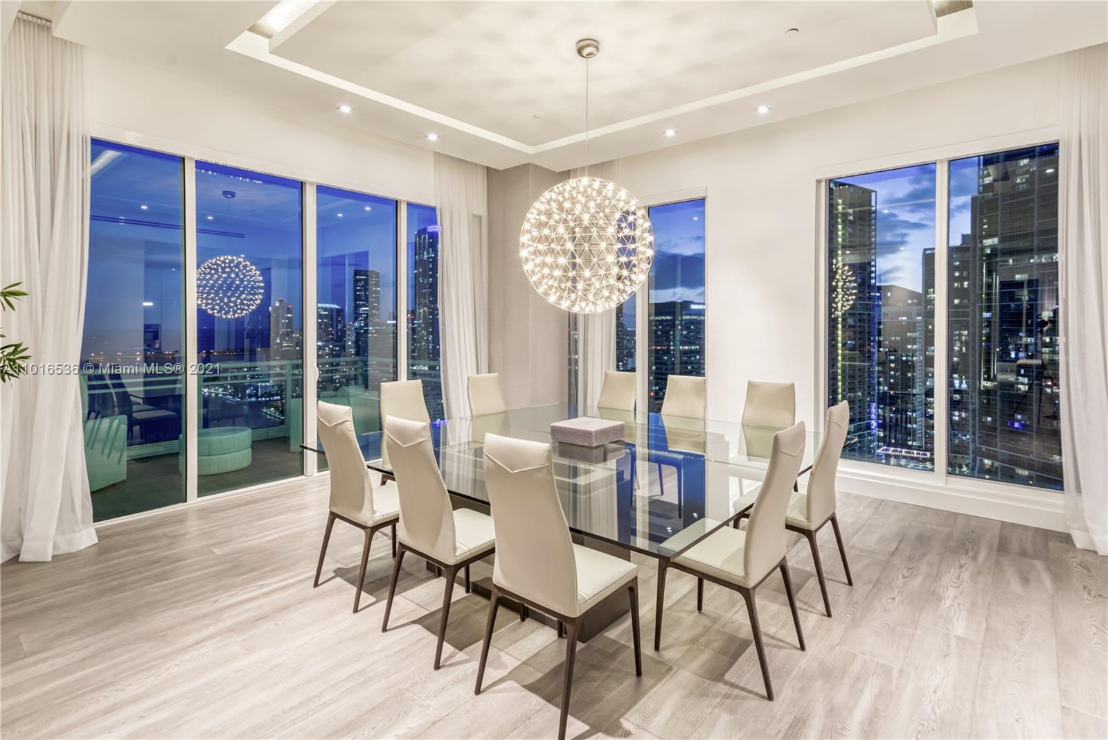 900 Brickell Key Boulevard, Unit PH4 Miami, FL 33131 - Photo 19 of 79 a view of a dining room with furniture and wooden floor