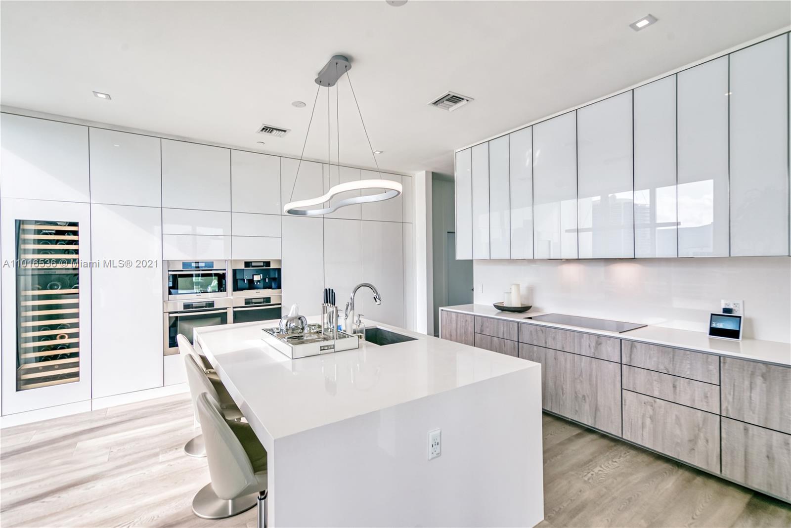 900 Brickell Key Boulevard, Unit PH4 Miami, FL 33131 - Photo 20 of 79 a kitchen with stainless steel appliances kitchen island granite countertop a sink a stove and cabinets
