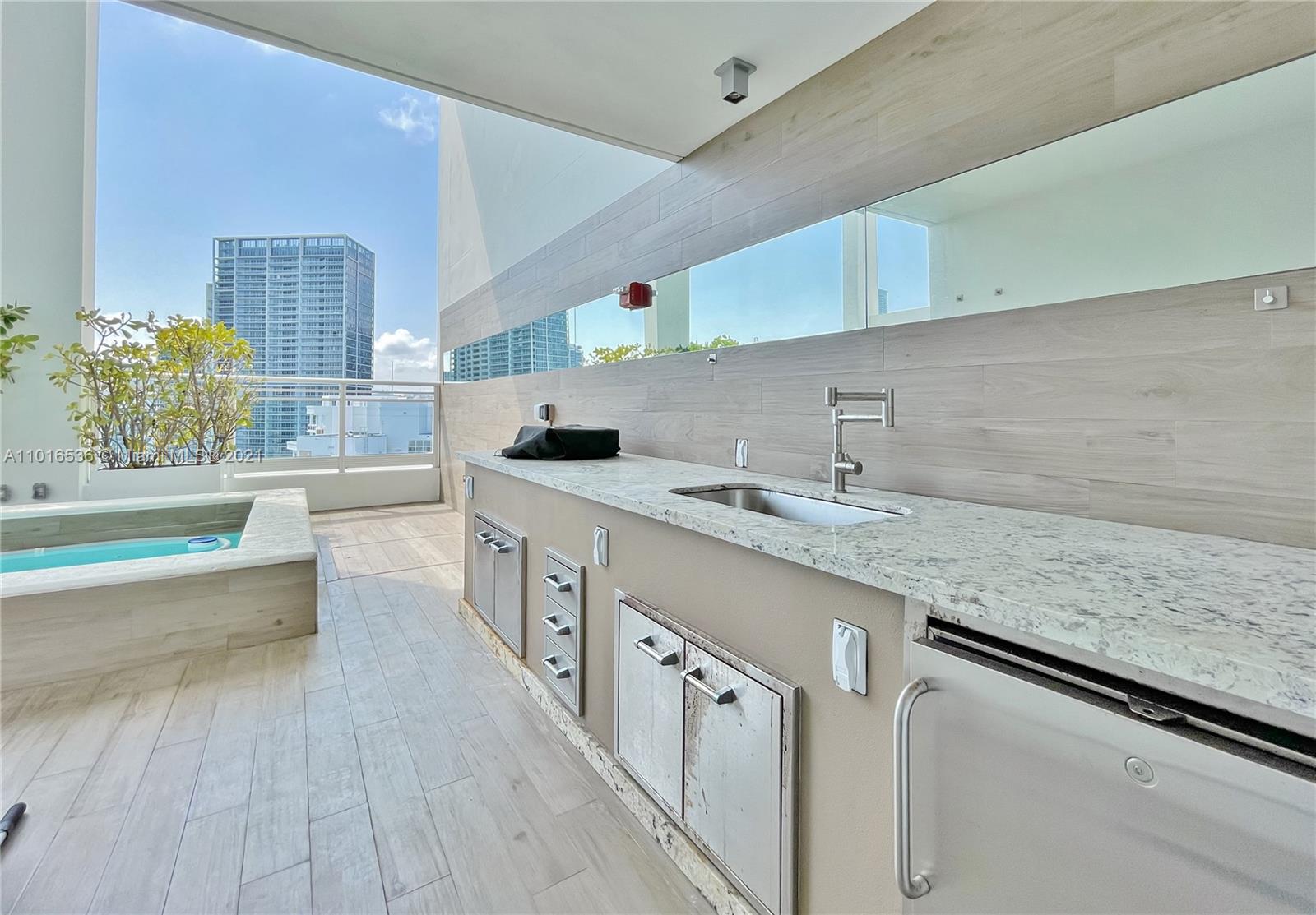 900 Brickell Key Boulevard, Unit PH4 Miami, FL 33131 - Photo 46 of 79 a kitchen with granite countertop a sink and cabinets
