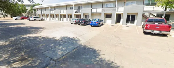 a view of a building with cars parked in front of it