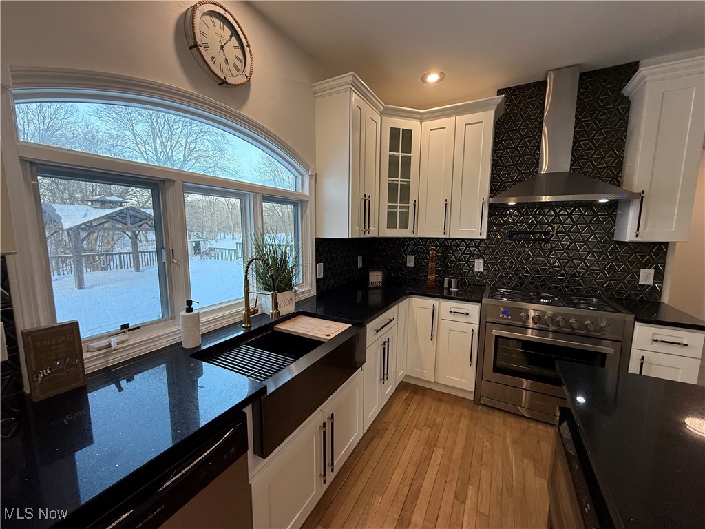 31295 Arthur Road Solon, OH 44139 - Photo 18 of 50 Kitchen with white cabinets, sink, wall chimney exhaust hood, and appliances with stainless steel finishes
