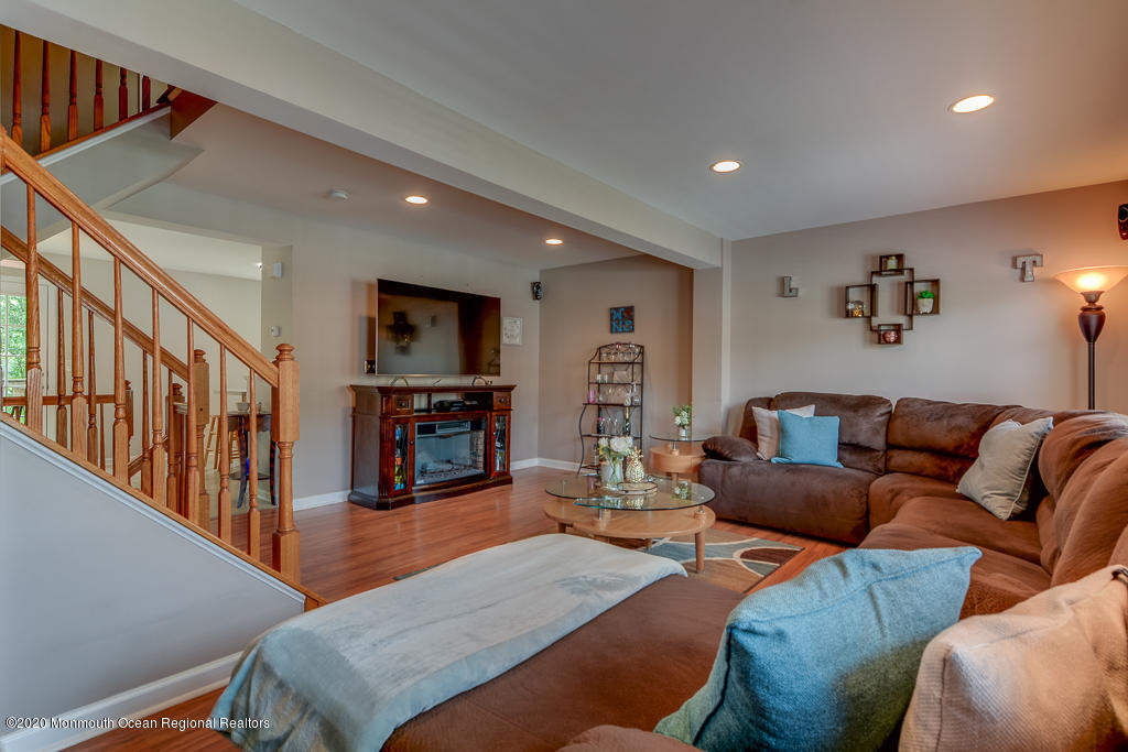 55 Saxton Road Farmingdale, NJ 07727 - Photo 12 of 23 a living room with furniture a fireplace and a flat screen tv