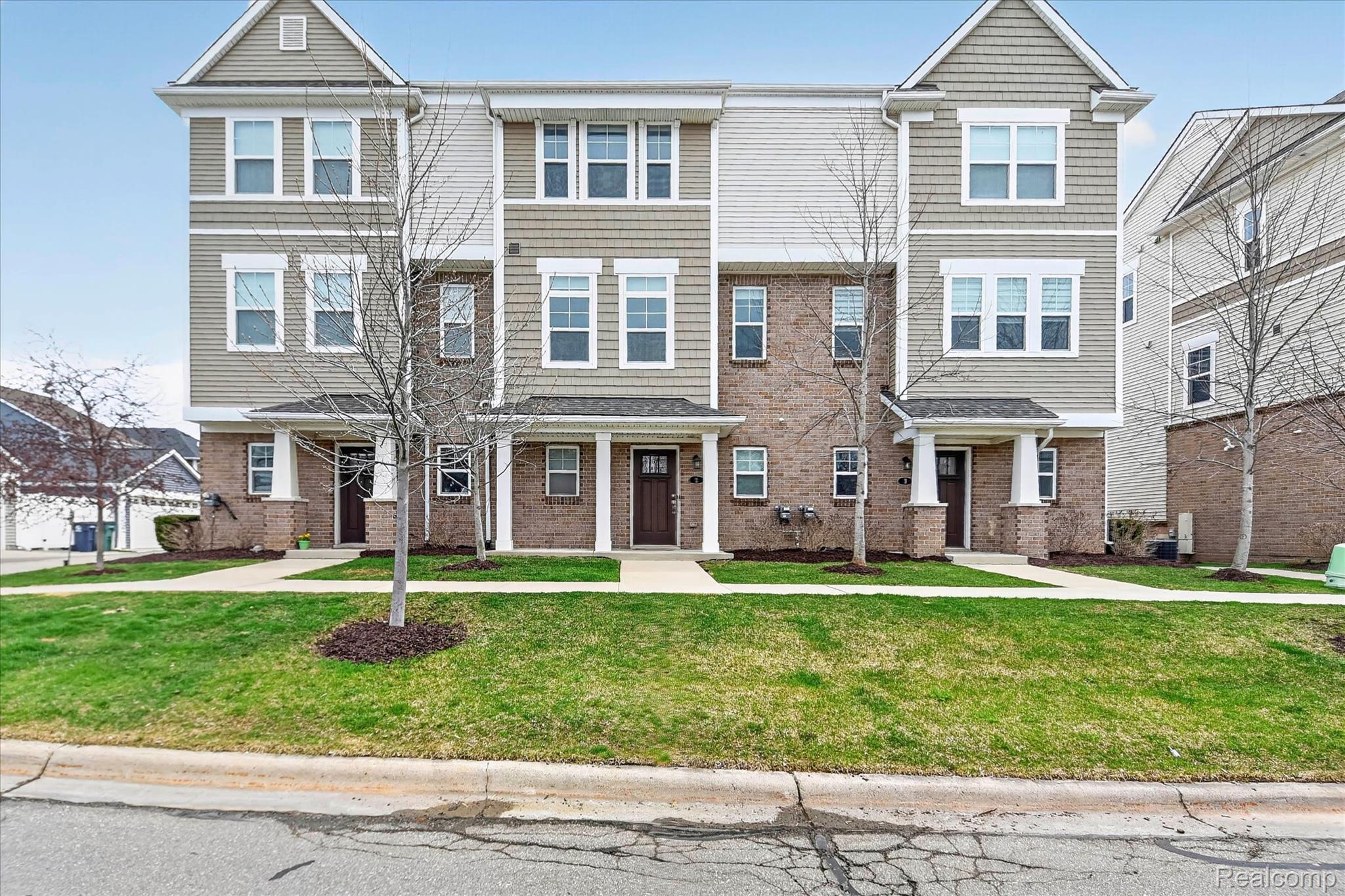 2500 Normandy Road, Unit 2 Royal Oak, MI 48073 - Photo 2 of 38 Townhome exterior featuring brick and siding facade, covered entryways, and multiple windows