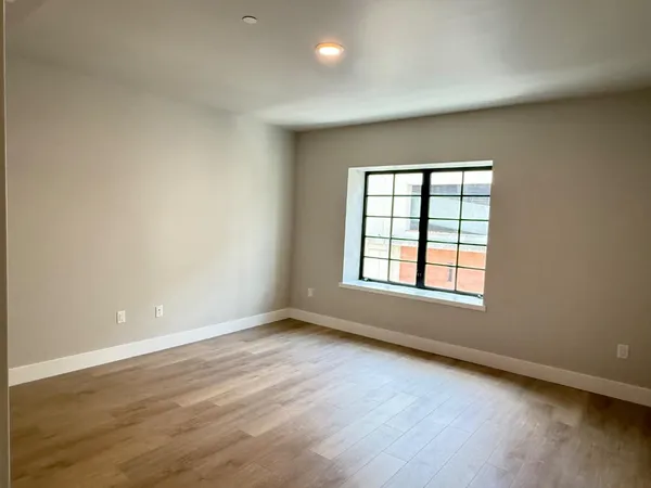 a view of an empty room with wooden floor