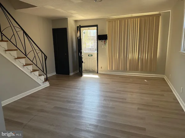 a view of a hallway with wooden floor and stairs