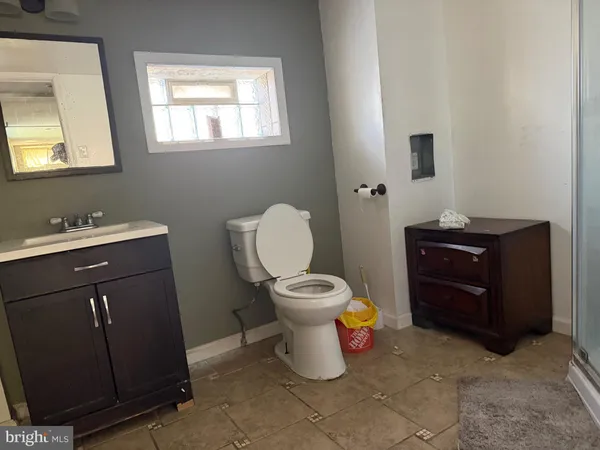 a bathroom with a toilet a sink and mirror