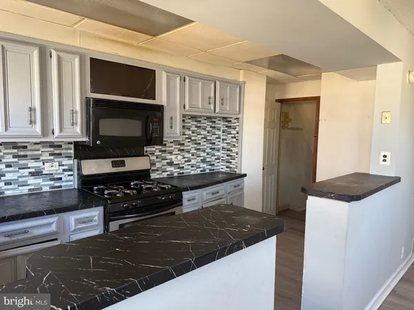 a kitchen with stainless steel appliances kitchen island granite countertop a stove and a microwave