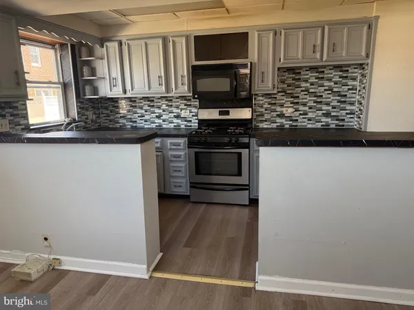 a kitchen with stainless steel appliances a stove and microwave