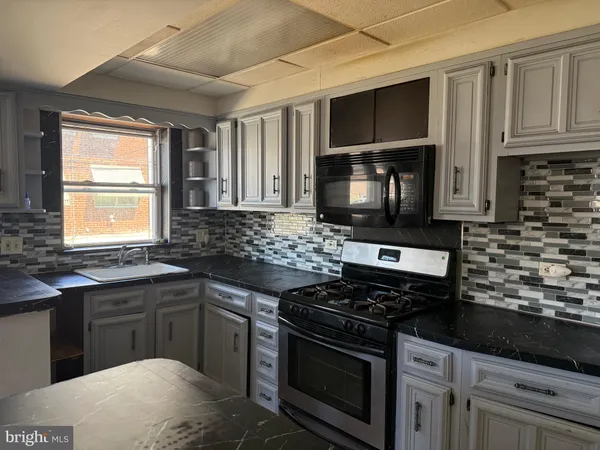 a kitchen with stainless steel appliances granite countertop a stove microwave and sink