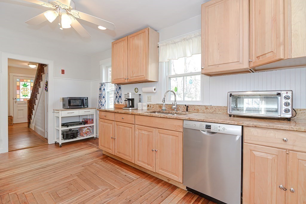 103 Maple Avenue Rutland, MA 01543 - Photo 11 of 42 a kitchen with kitchen island granite countertop a stove a sink and white cabinets with wooden floor