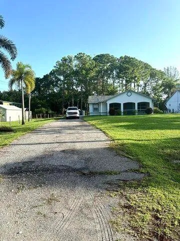 a front view of a house with a yard and trees