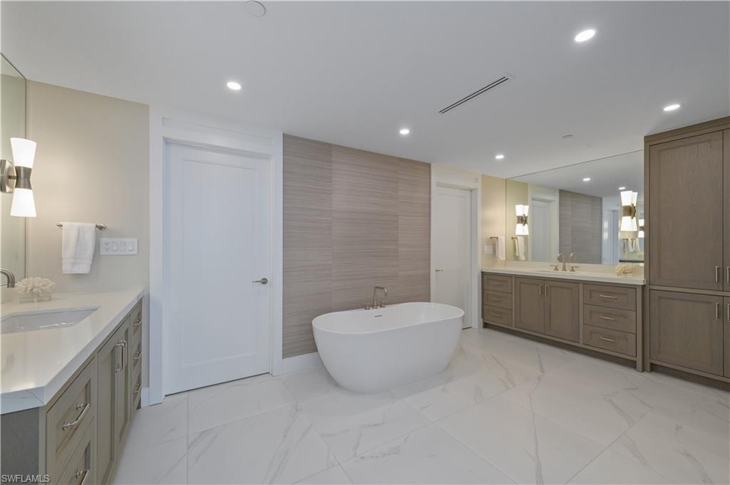 13945 Old Coast Road, Unit 1606 Naples, FL 34110 - Photo 13 of 35 a bathroom with a granite countertop sink a toilet and bathtub
