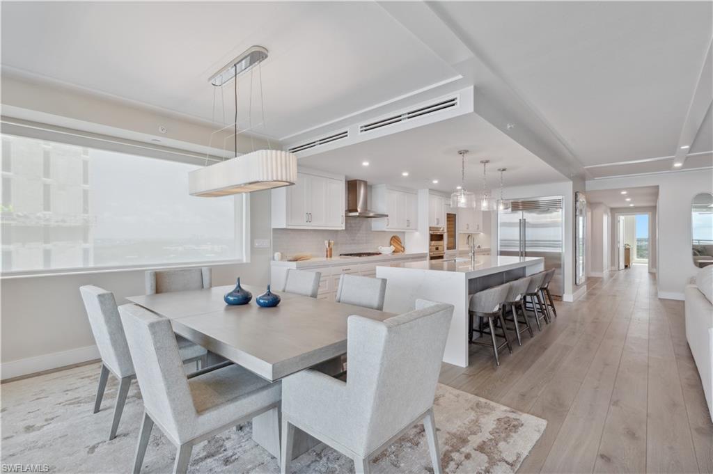 13945 Old Coast Road, Unit 1606 Naples, FL 34110 - Photo 6 of 35 a dining room with stainless steel appliances kitchen island granite countertop a dining table chairs and view living room