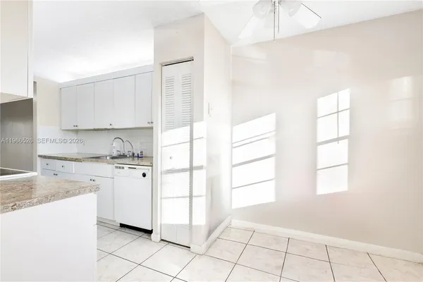 a kitchen with granite countertop white cabinets and white appliances