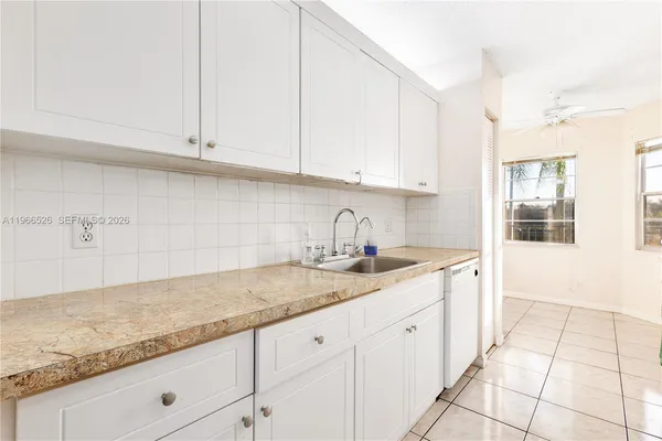 a kitchen with granite countertop white cabinets and white appliances