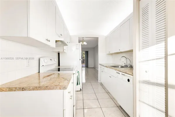 a large kitchen with granite countertop a sink and a stove
