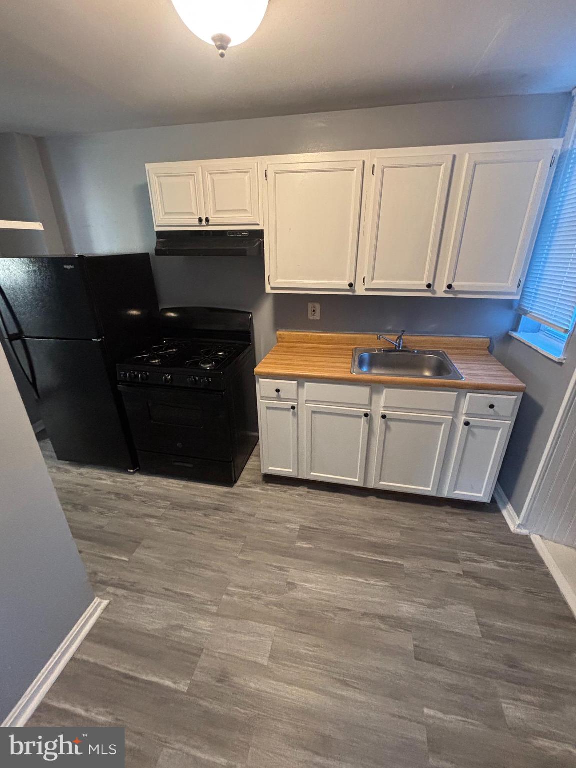 1501 North Payson Street Baltimore, MD 21217 - Photo 5 of 13 a kitchen with granite countertop white cabinets and black appliances
