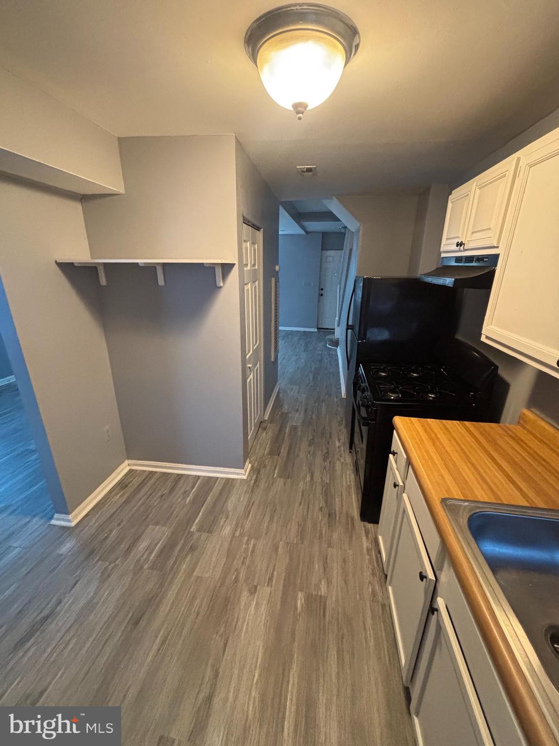 1501 North Payson Street Baltimore, MD 21217 - Photo 6 of 13 a kitchen with a wooden floor and a stove
