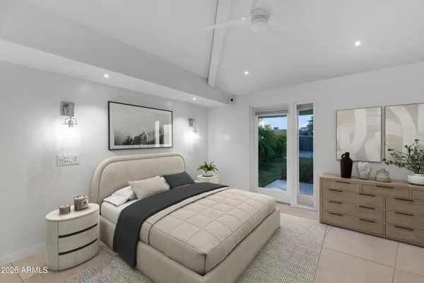 a bedroom with a large bed and a chandelier