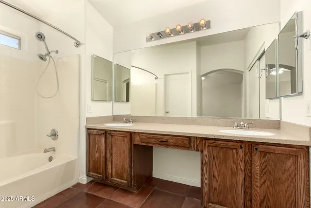 a bathroom with a granite countertop sink mirror and a bathtub