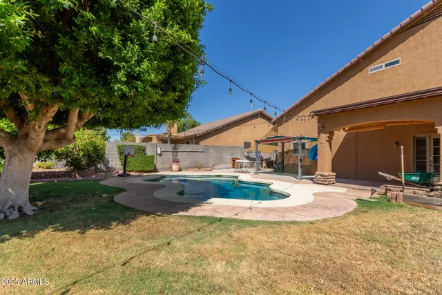 a view of a house with backyard and tree