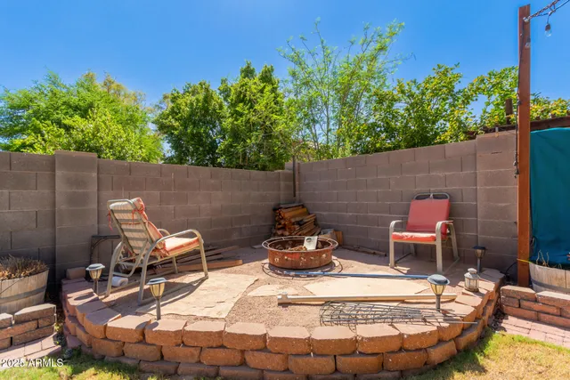 a view of a backyard with table and chairs potted plants