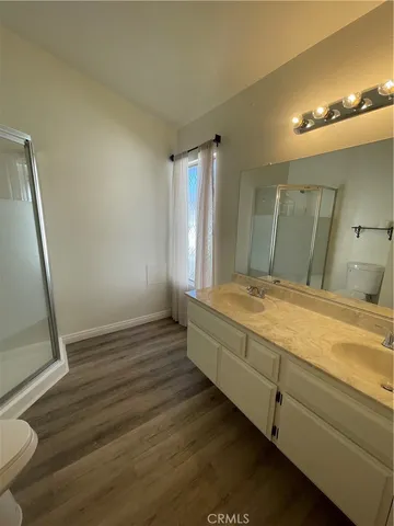 a spacious bathroom with a granite countertop sink a toilet a mirror and vanity