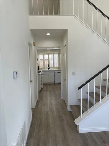 a view of a hallway with wooden floor and staircase