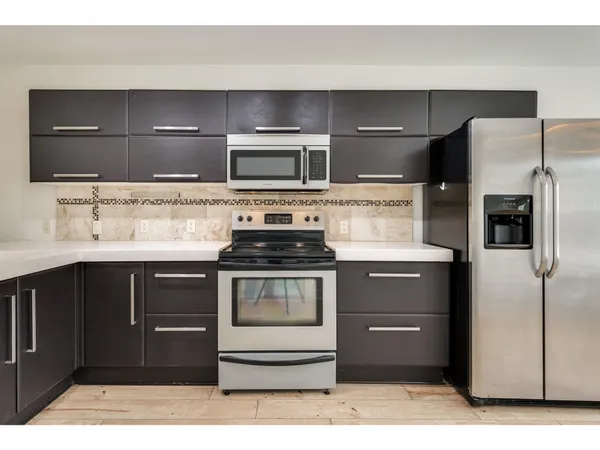 a kitchen with stainless steel appliances kitchen island granite countertop a stove and a microwave
