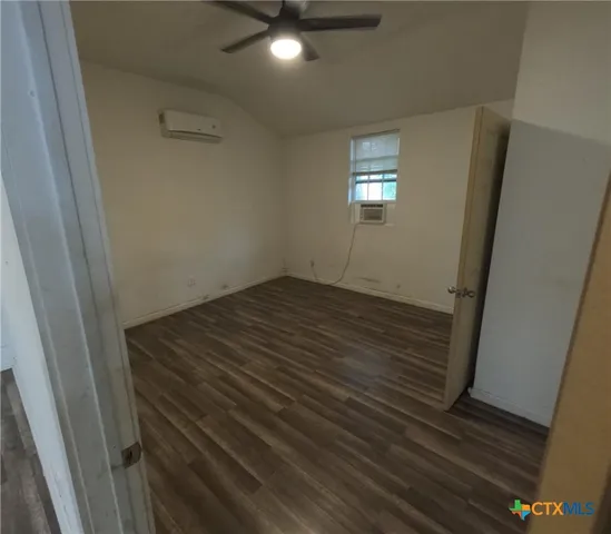 en empty room with wooden floor and window