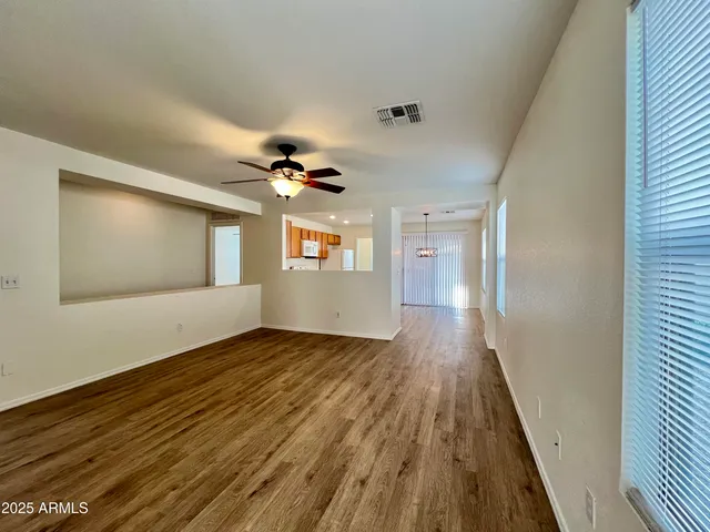 a view of an empty room window and wooden floor