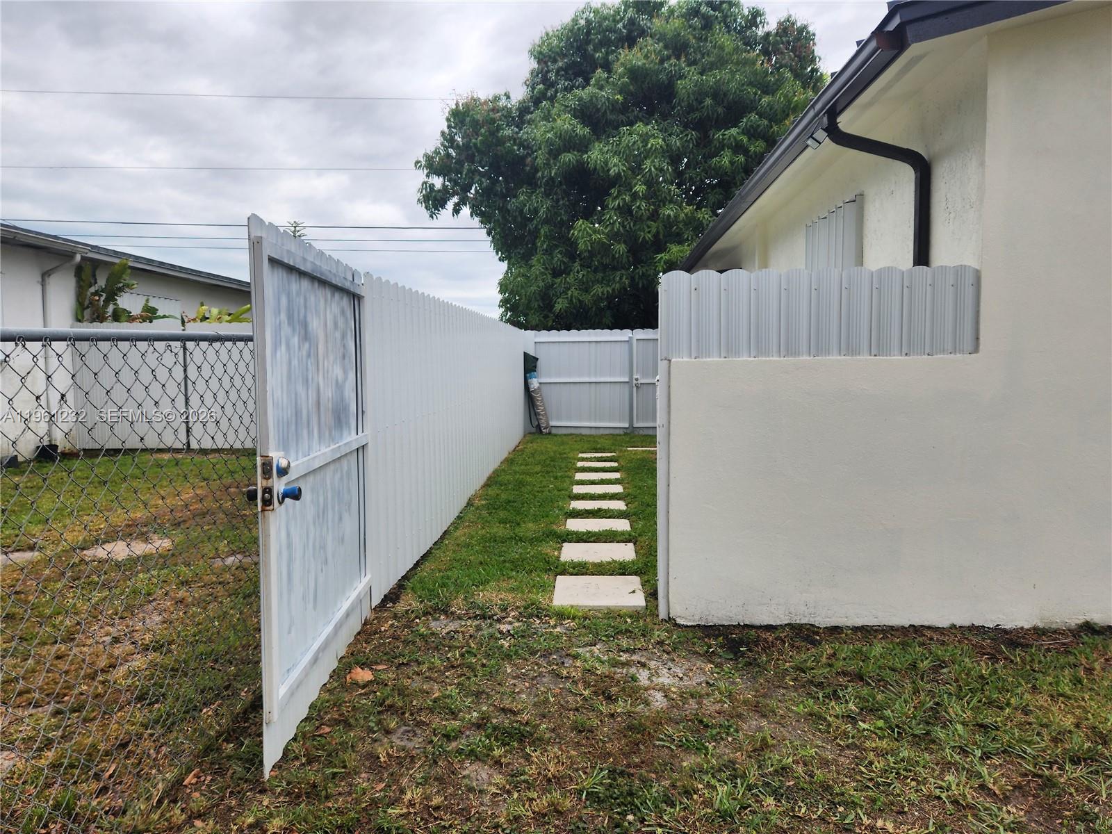 12460 Southwest 187th Terrace, Unit 1 Miami, FL 33177 - Photo 2 of 16 a front view of a house with a yard
