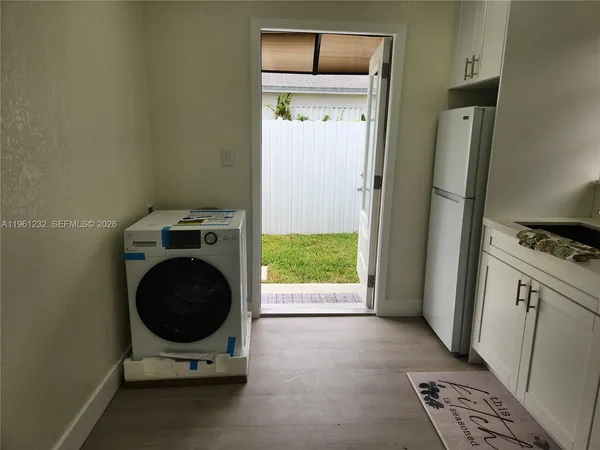 a view of empty room with wooden floor and window