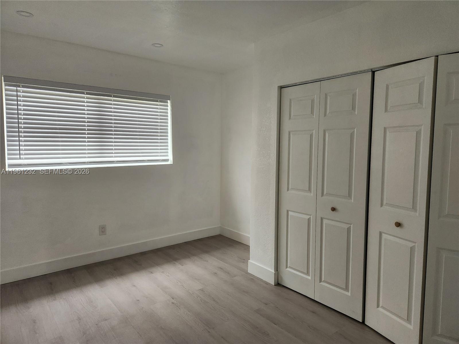 12460 Southwest 187th Terrace, Unit 1 Miami, FL 33177 - Photo 9 of 16 a view of an empty room with wooden floor and a window