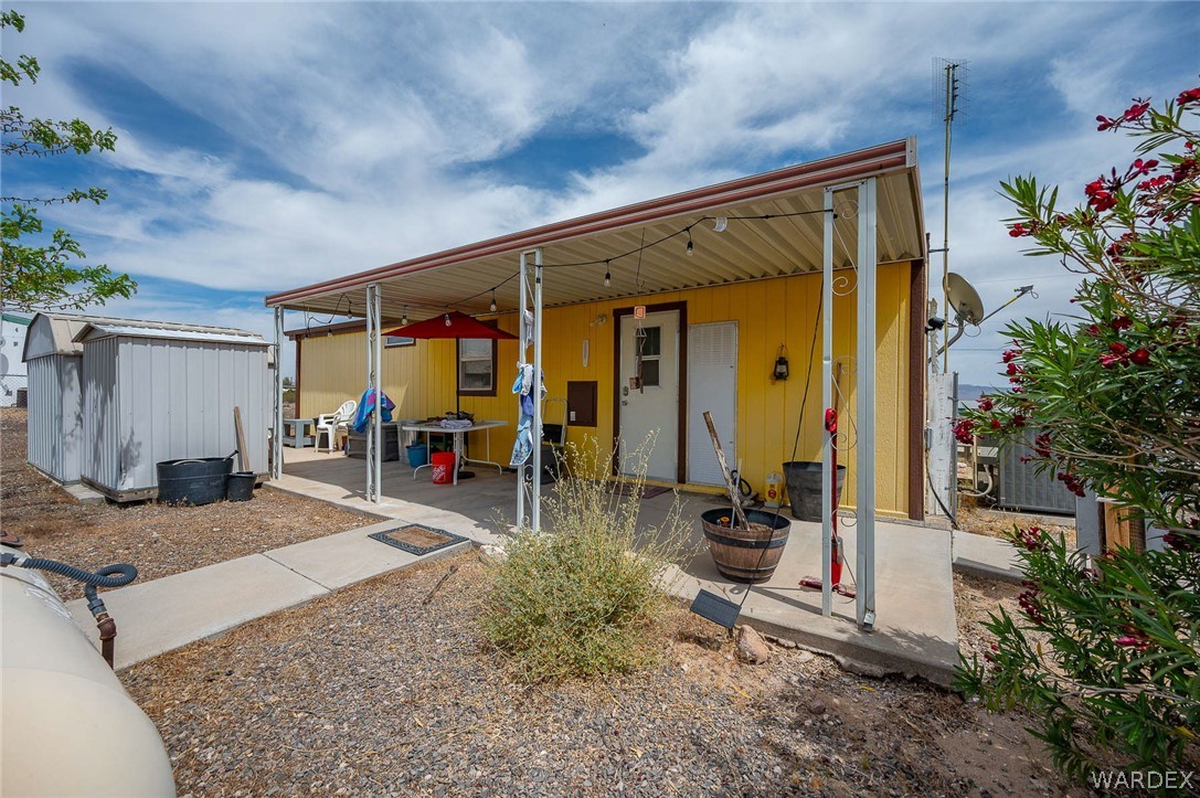 2465 Egar Road Golden Valley, AZ 86413 - Photo 37 of 98 The property features a yellow exterior and a covered patio with string lights
