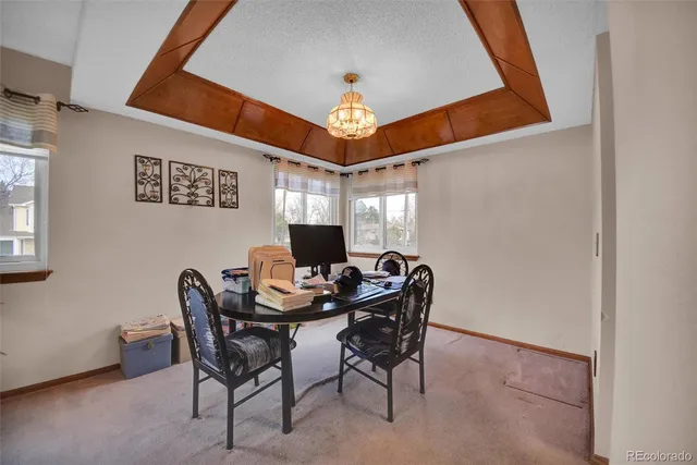 a view of a dining room with furniture and a chandelier