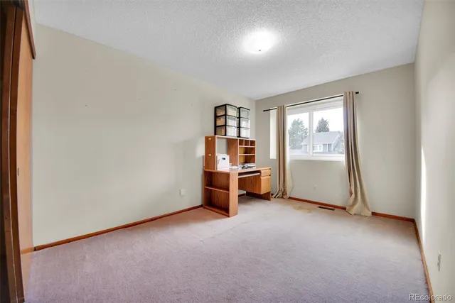 an empty room with a cabinet and mirrors