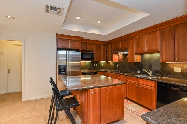 a kitchen with stainless steel appliances granite countertop a stove refrigerator sink and cabinets