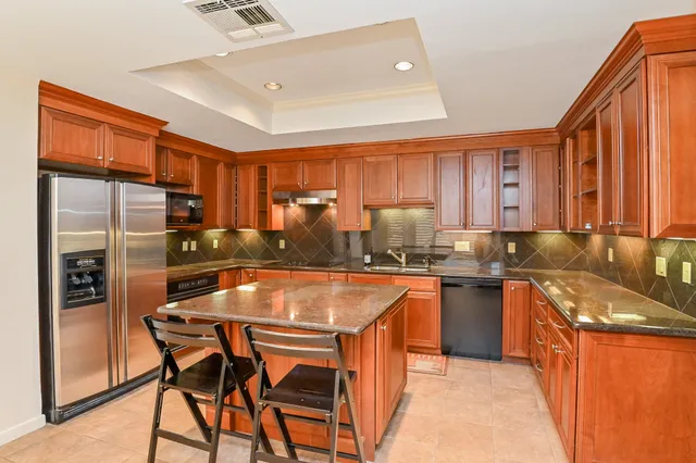 a kitchen with granite countertop stainless steel appliances and cabinets