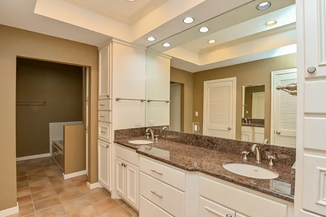 a spacious bathroom with a granite countertop sink and a mirror