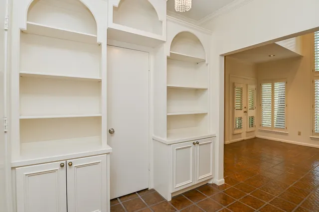 a view of an empty room with cabinet and a window