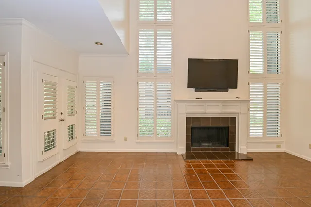 a view of an empty room with a fireplace and a window