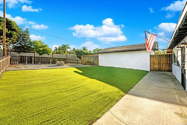 a swimming pool with yard in the back