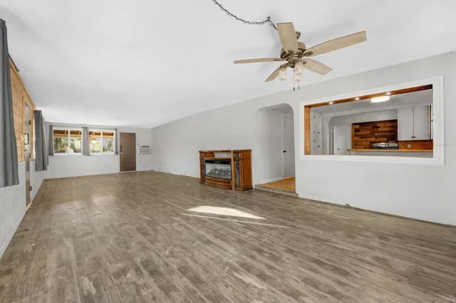 a view of a livingroom with wooden floor and a ceiling fan