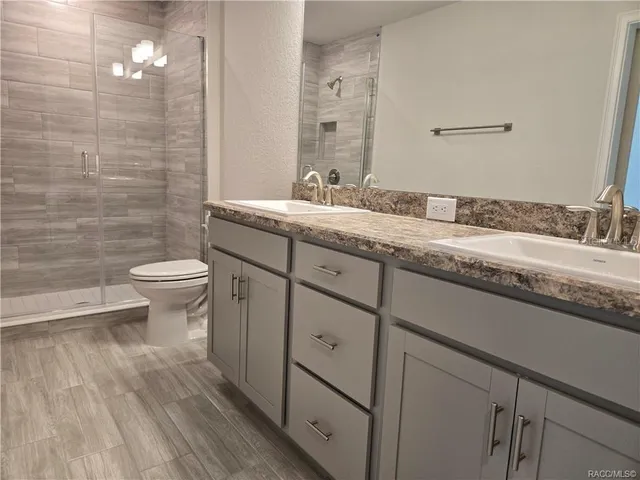 a bathroom with a granite countertop sink toilet and a mirror