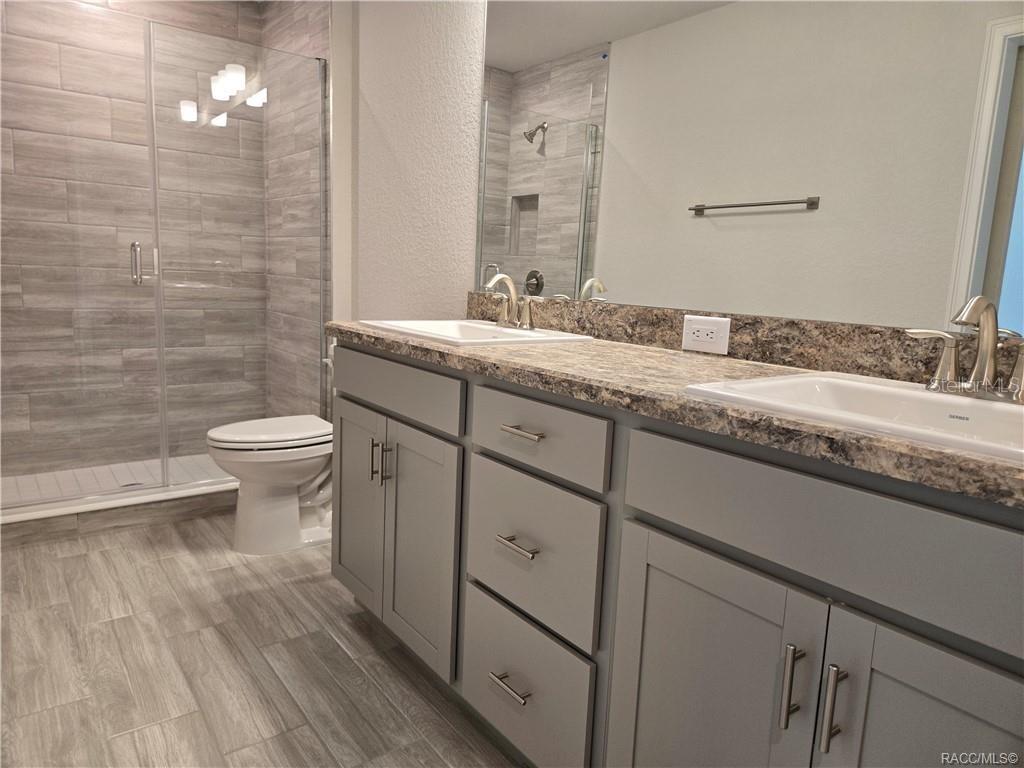 279 Bittern Loop Inverness, FL 34453 - Photo 13 of 30 a bathroom with a granite countertop sink toilet and a mirror
